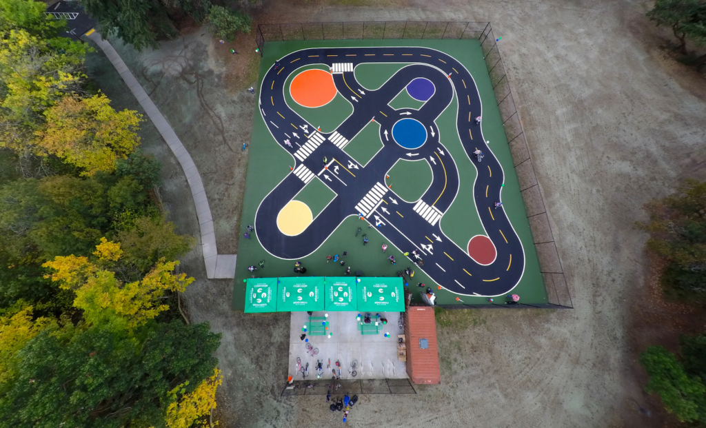 aerial view of miniature streets and traffic circles painted onto asphalt surface.